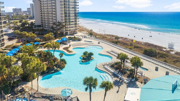 A resort with a large pool, beach access, and high-rise buildings.