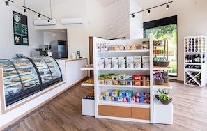 Een bakkerijdisplay met gebak en een koffieapparaat op de achtergrond.