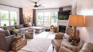 A modern living room with a grey sofa, a round coffee table, and a fireplace. - Sunset Oasis|PrivateDock|Sleeps8 (Chappells)