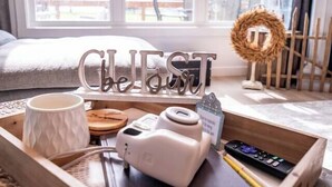 A wooden tray with a camera, a mug, a remote control, and a tray with a name sign. - Sunset Oasis|PrivateDock|Sleeps8 (Chappells)