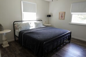 A bedroom with a bed, bedside tables, a lamp, and a window. - Meadow Lane In Hocking Hills (Logan)