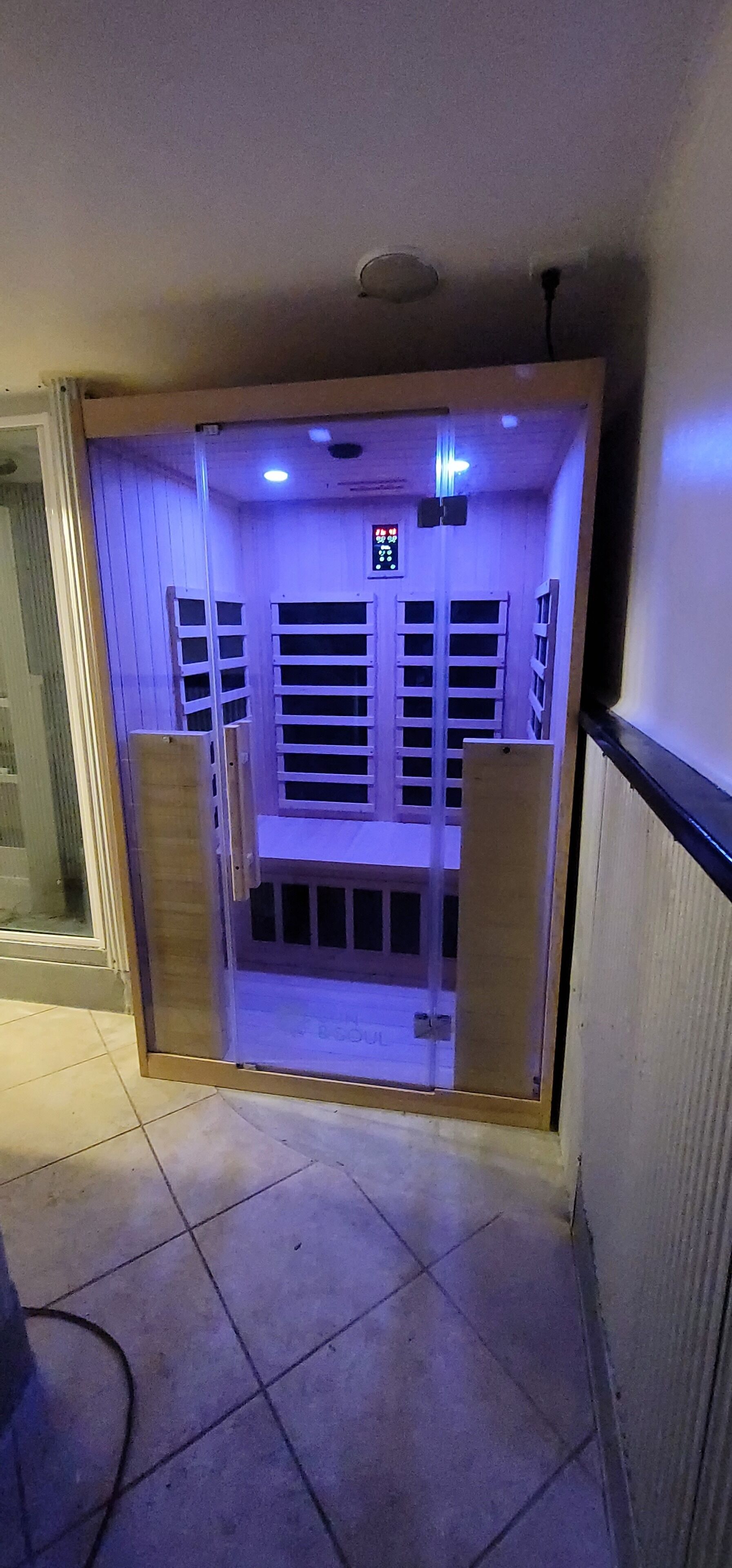Una habitación con puerta corredera, suelo de baldosas y una lámpara en el techo.
