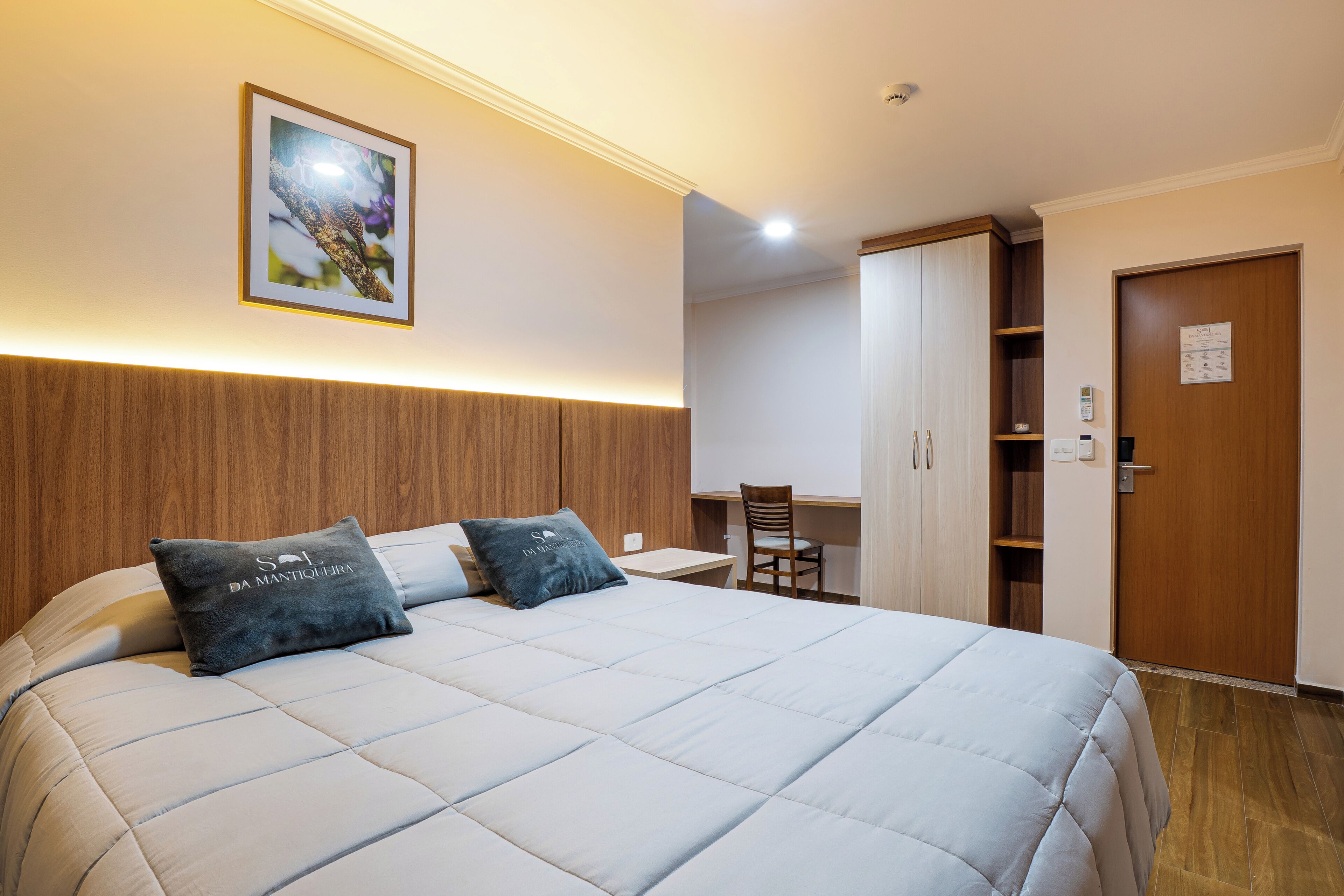 Une chambre d’hôtel avec un lit, un bureau et une armoire.