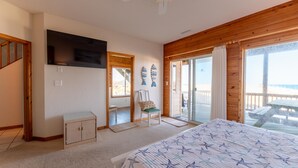 Un dormitorio con cama, televisión, una silla y vistas al exterior.