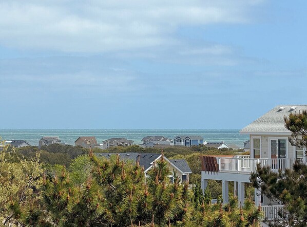 Zona residencial costera con casas y una playa al fondo.