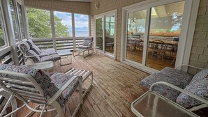 Un espacio de descanso al aire libre con sillones acolchados y una terraza de madera.