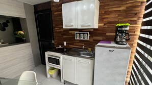 Een moderne keuken met witte kasten, een ingebouwde oven en een koffiezetapparaat.