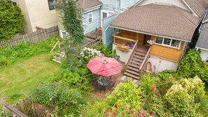 A residential property with a front porch, a wooden staircase, and a fenced backyard. - Peaceful Kits Garden Stay (Vancouver)