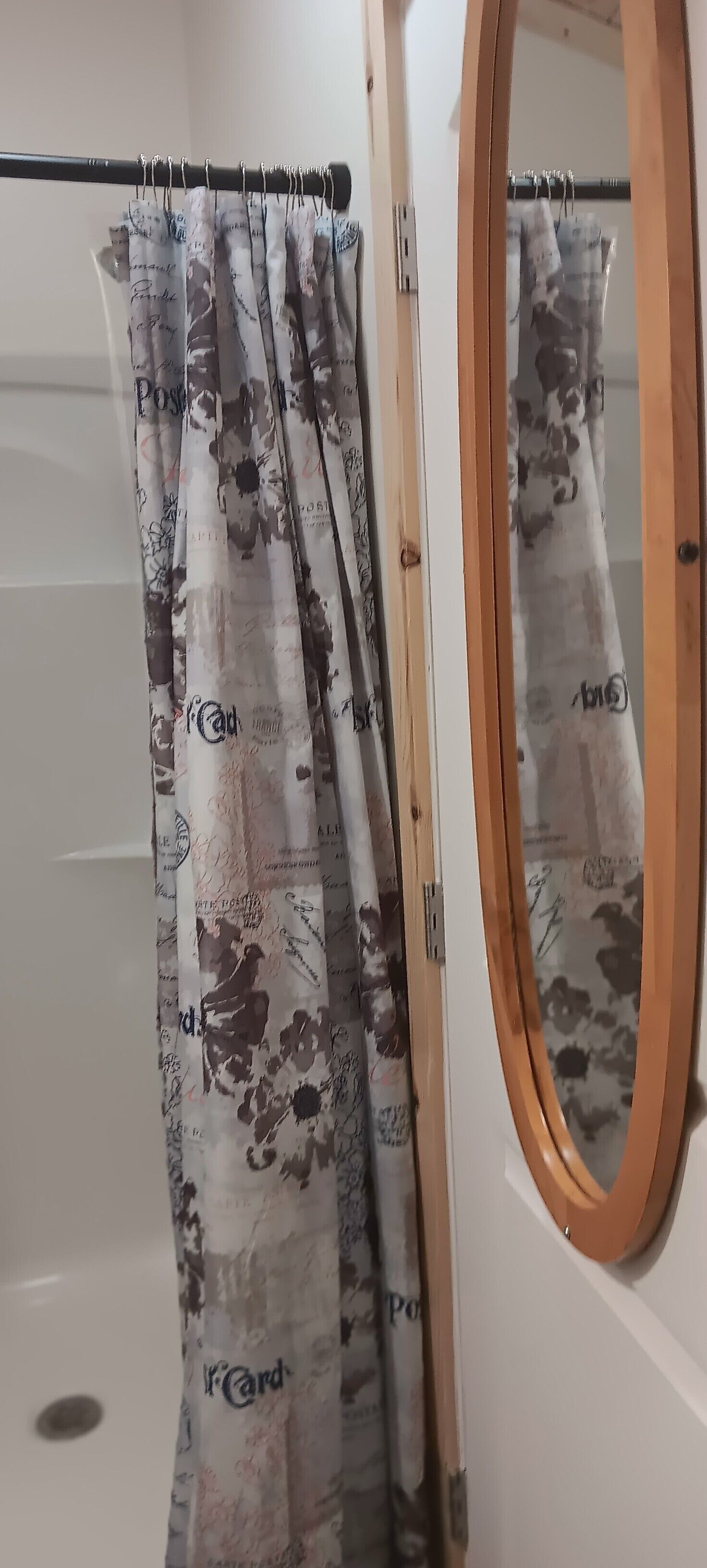 Un bagno con tenda da doccia decorata con un motivo floreale e la scritta 'Card' ben visibile.