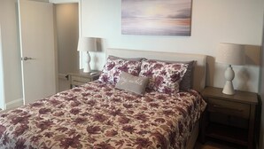 A bedroom with a bed, two bedside tables with lamps, a painting on the wall, and a door. - Valle verde get-away in upscale neiborhood! (Poway)