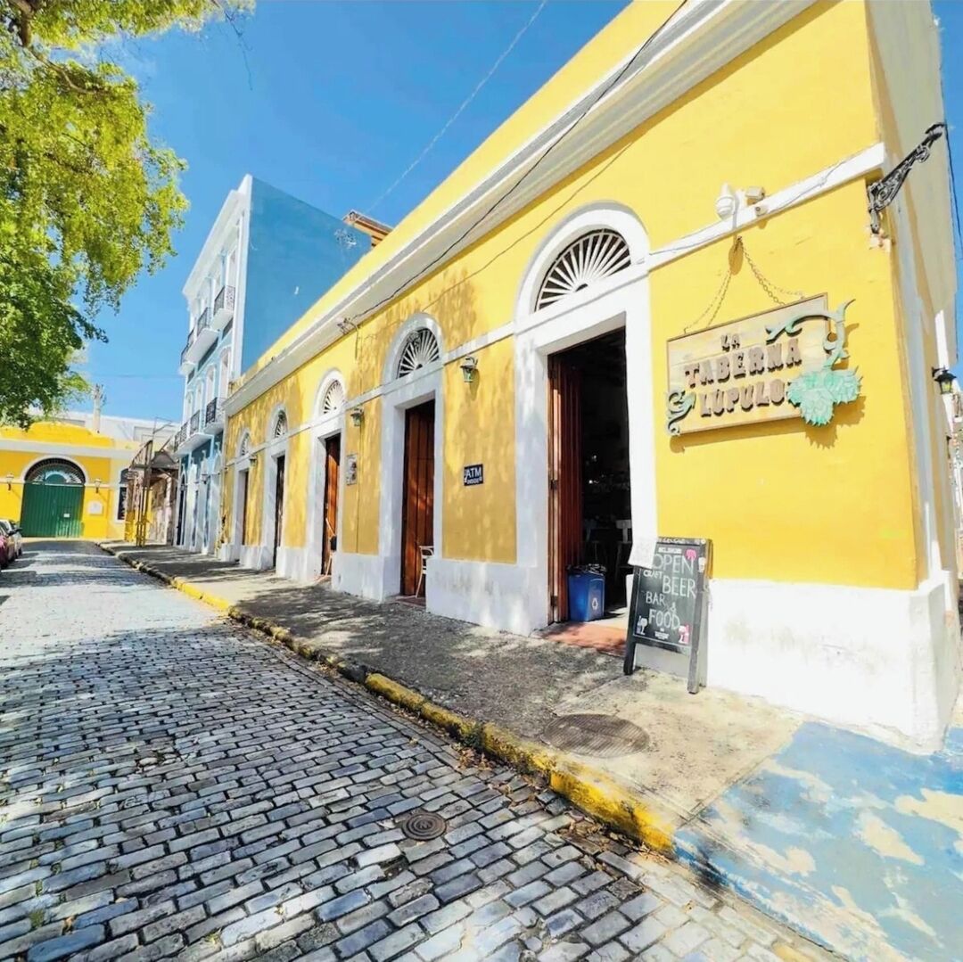 A yellow building with a sign reading "La Taberna Tupelo".