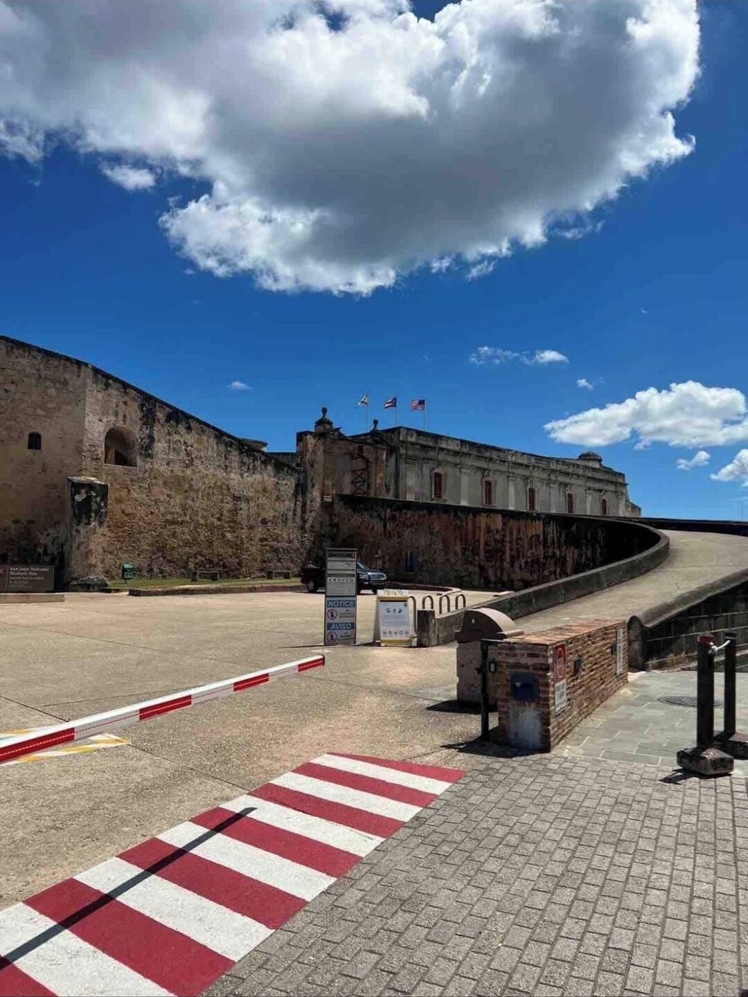 Una fortaleza histórica con un camino pavimentado que conduce a una entrada portonada.
