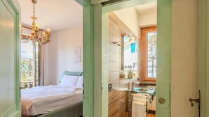 Une chambre à coucher avec un lit, un lustre et une vue sur l’extérieur.