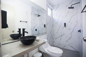 Junior vierpersoonskamer | Badkamer | Een bad, handdoeken, zeep, shampoo