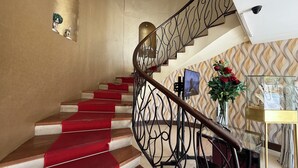 A staircase with red carpeted steps and a decorative railing. - Downtown Suites - Hotel Boutique by Maraf (Cancún)