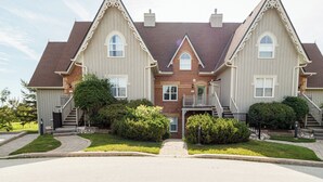 A large, two-story house with a symmetrical facade, a central entrance, and a small porch.