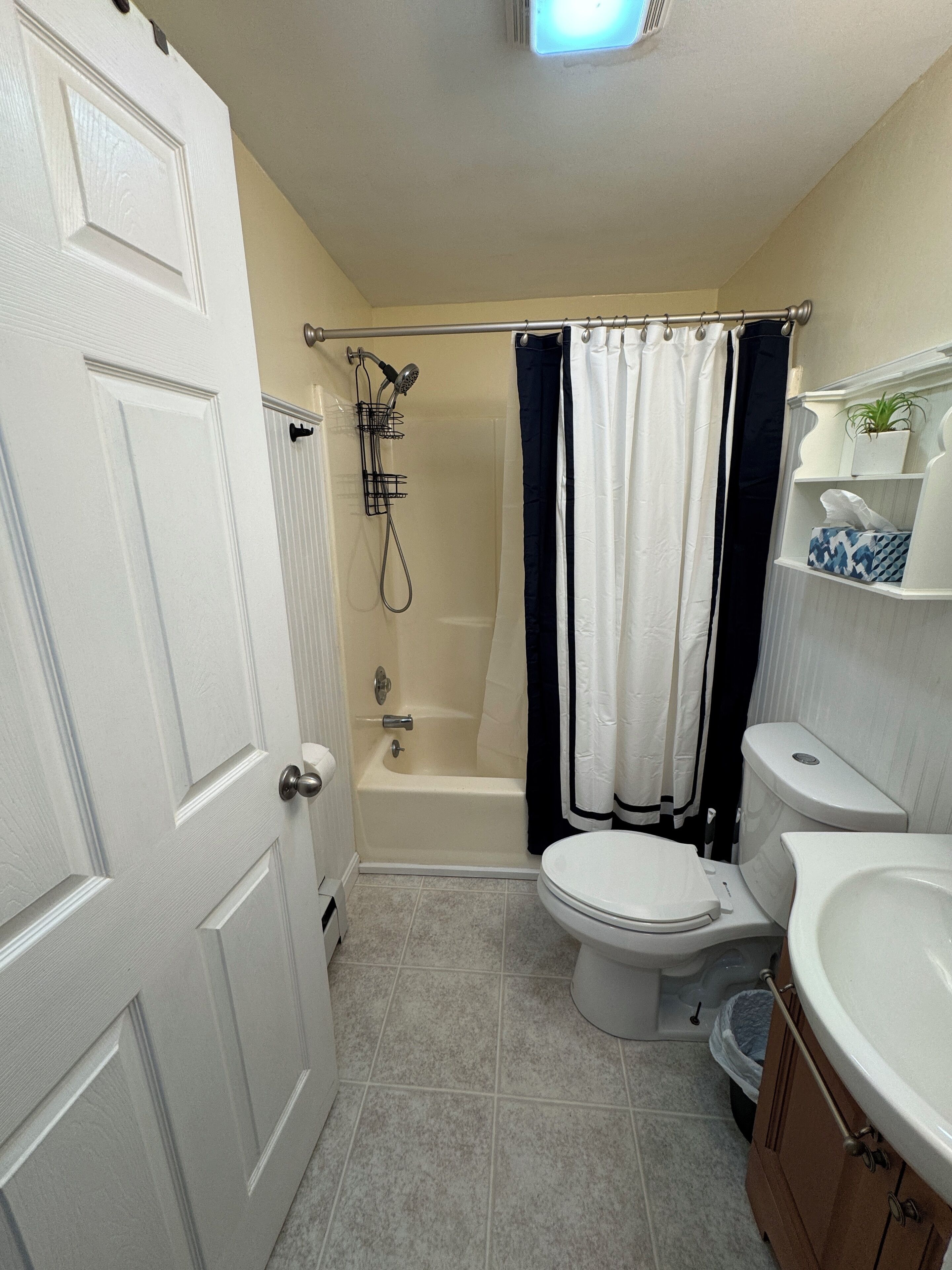 A bathroom with a bathtub, toilet, and sink.