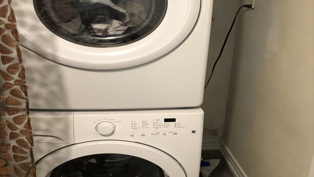 Lavadora y secadora apiladas en un cuarto de lavado.