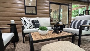 A modern living room with a sofa, armchairs, a coffee table, and a rug.