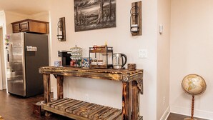 Une cuisine avec une console en bois, un réfrigérateur et un globe posé sur le sol.