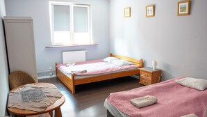 A bedroom with a bed, bedside table, chair, and a window. - La Perla (Międzyzdroje)