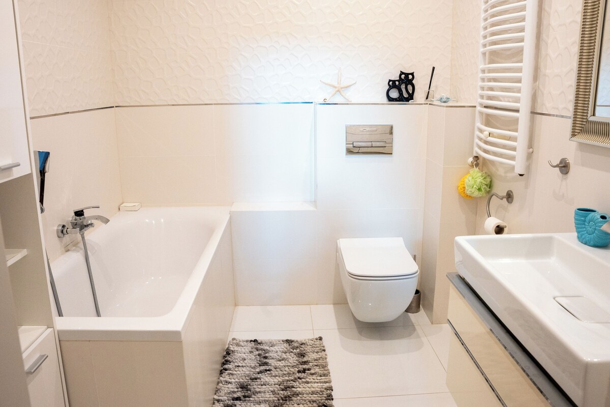 A modern bathroom with a bathtub, toilet, and sink.
