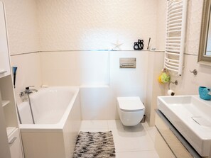 A modern bathroom with a bathtub, toilet, and sink. - La Perla (Międzyzdroje)