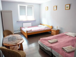 A bedroom with a bed, bedside table, chair, and a window. - La Perla (Międzyzdroje)