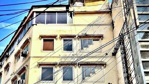 A multi-story building with a prominent red sign for ASKO International Hotel. - Hotel Asko International (New Delhi)