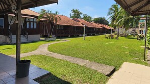 A courtyard with a covered seating area, a trash bin, and a sign for 'Curata Riveride Resort'. - Qurata Riverside Resort (Kuala Terengganu)