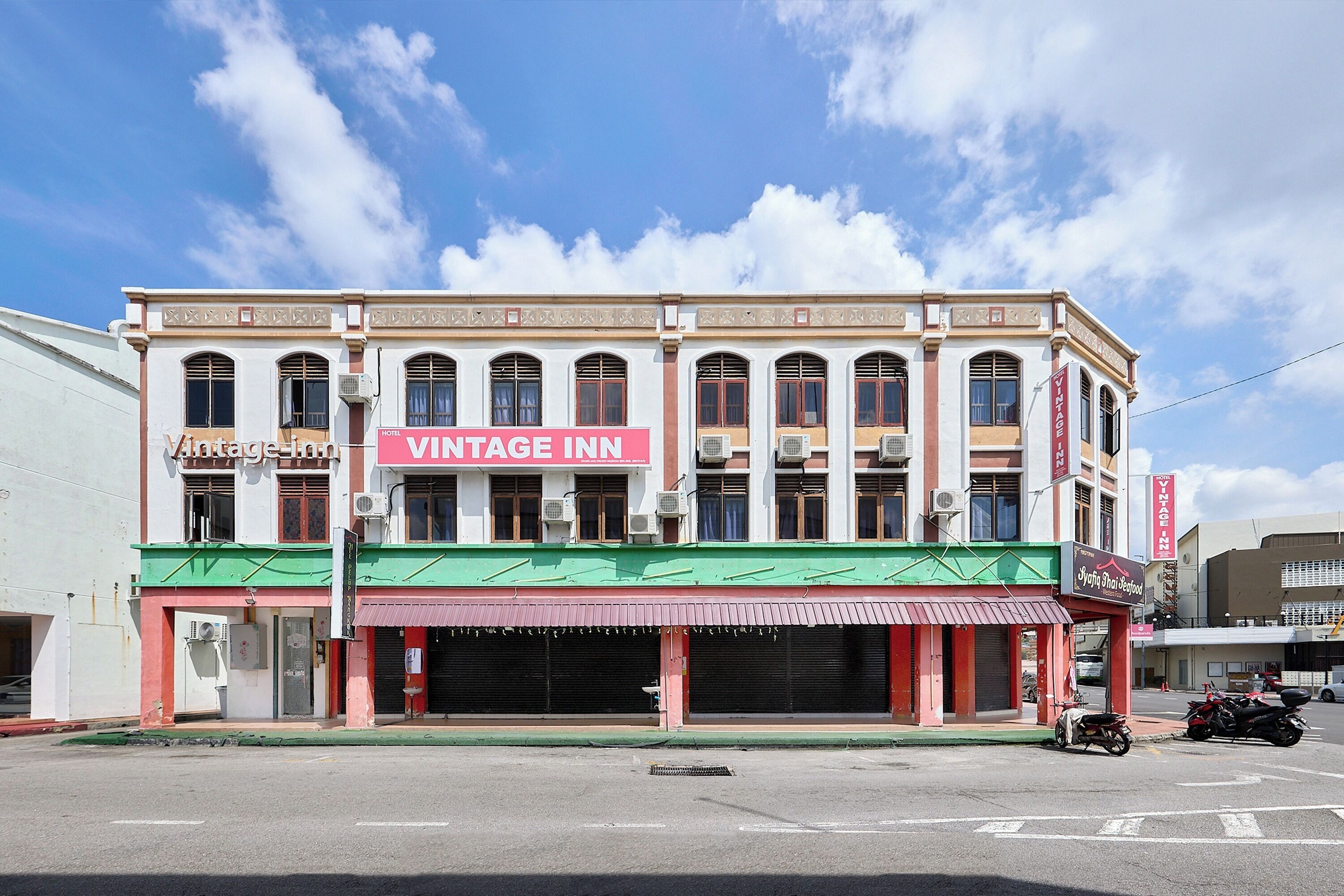 A building with a sign reading 'VINTAGE INN' and a storefront with closed shutters.