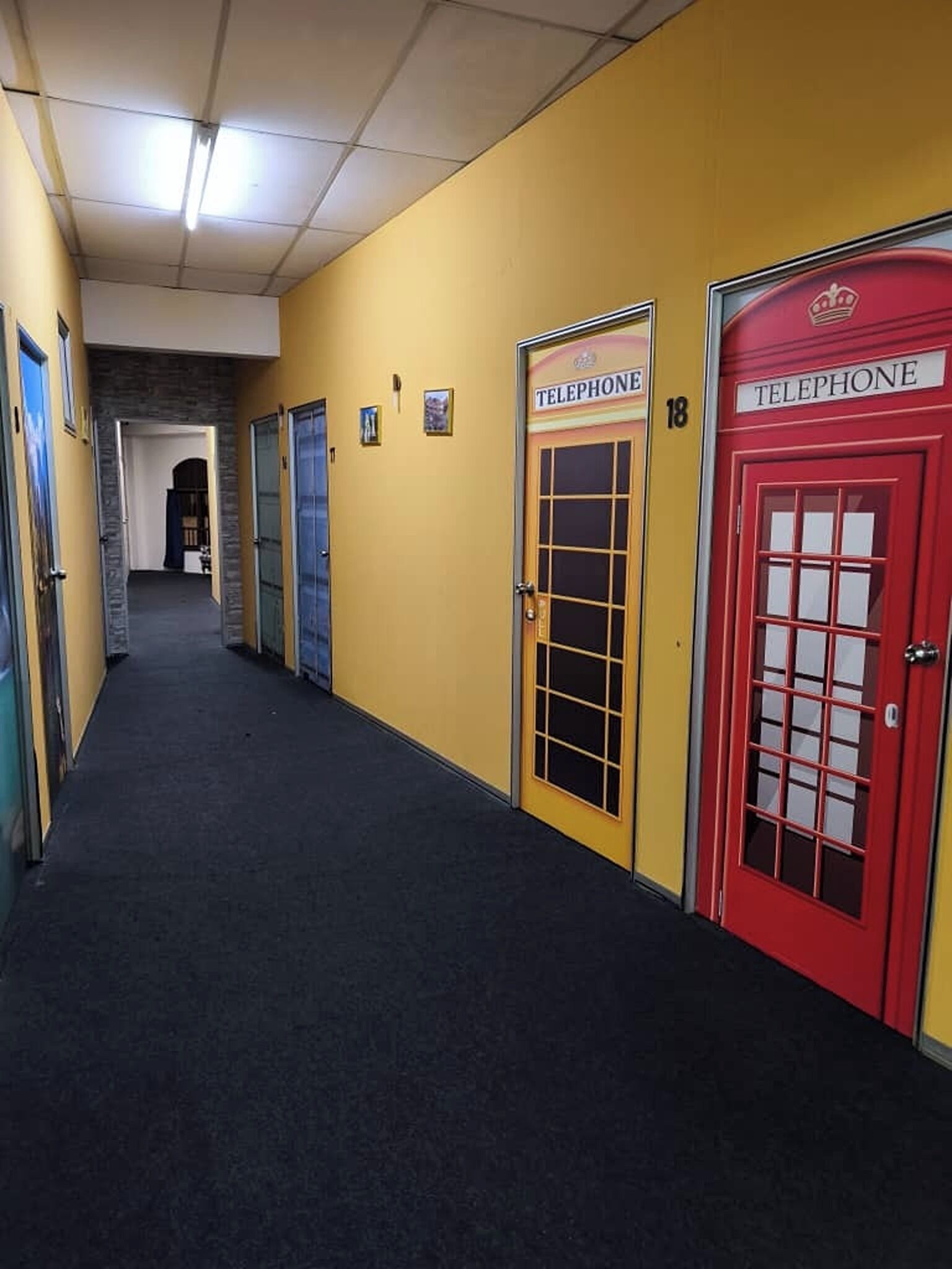A hallway with multiple telephone booths and a carpeted floor.