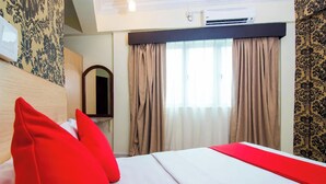 Une chambre d’hôtel avec un lit, un miroir et des rideaux.