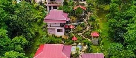 Un resort costero con varias edificaciones, una masa de agua y abundante vegetación.