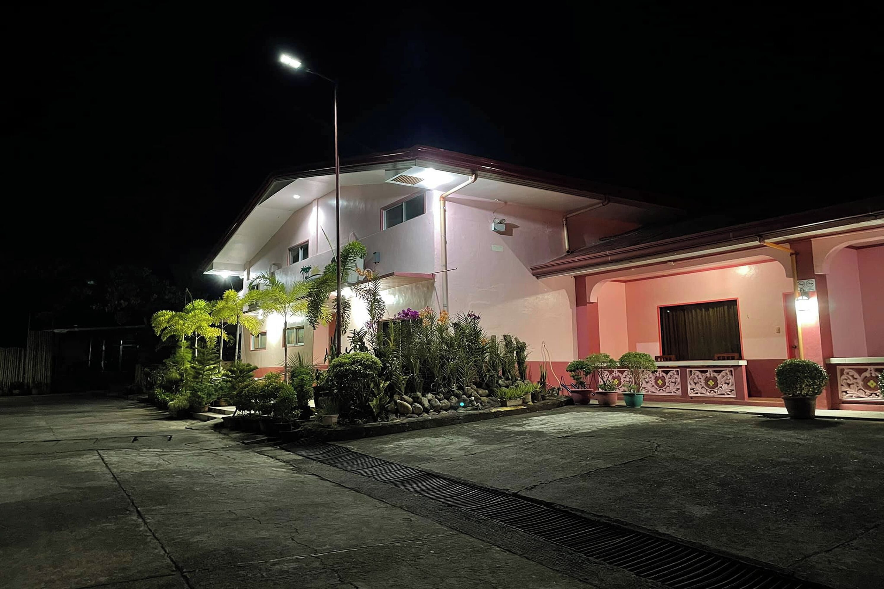A two-story building with a pink facade and a covered entrance area.