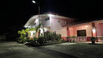 A two-story building with a pink facade and a covered entrance area.