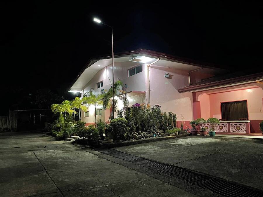A two-story building with a pink facade and a covered entrance area.