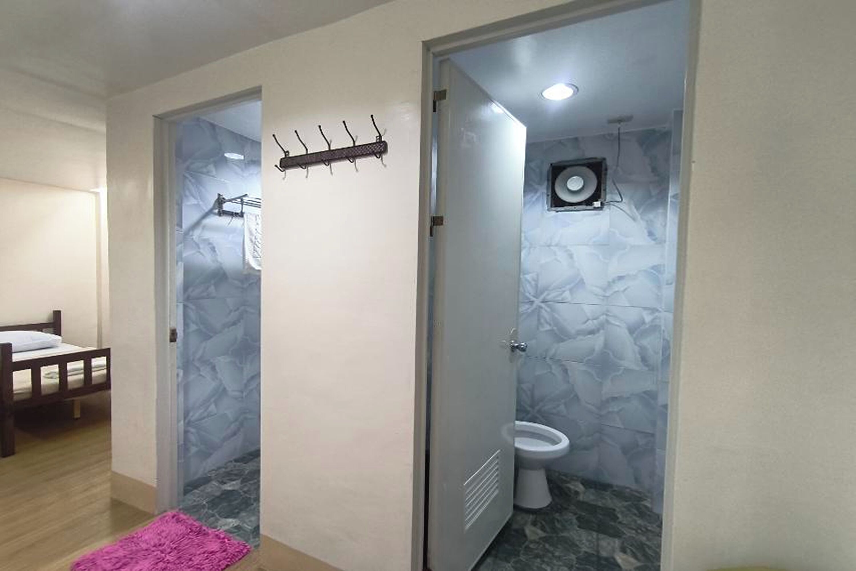 Een kamer met een bed, een badkamer met toilet en een douche.