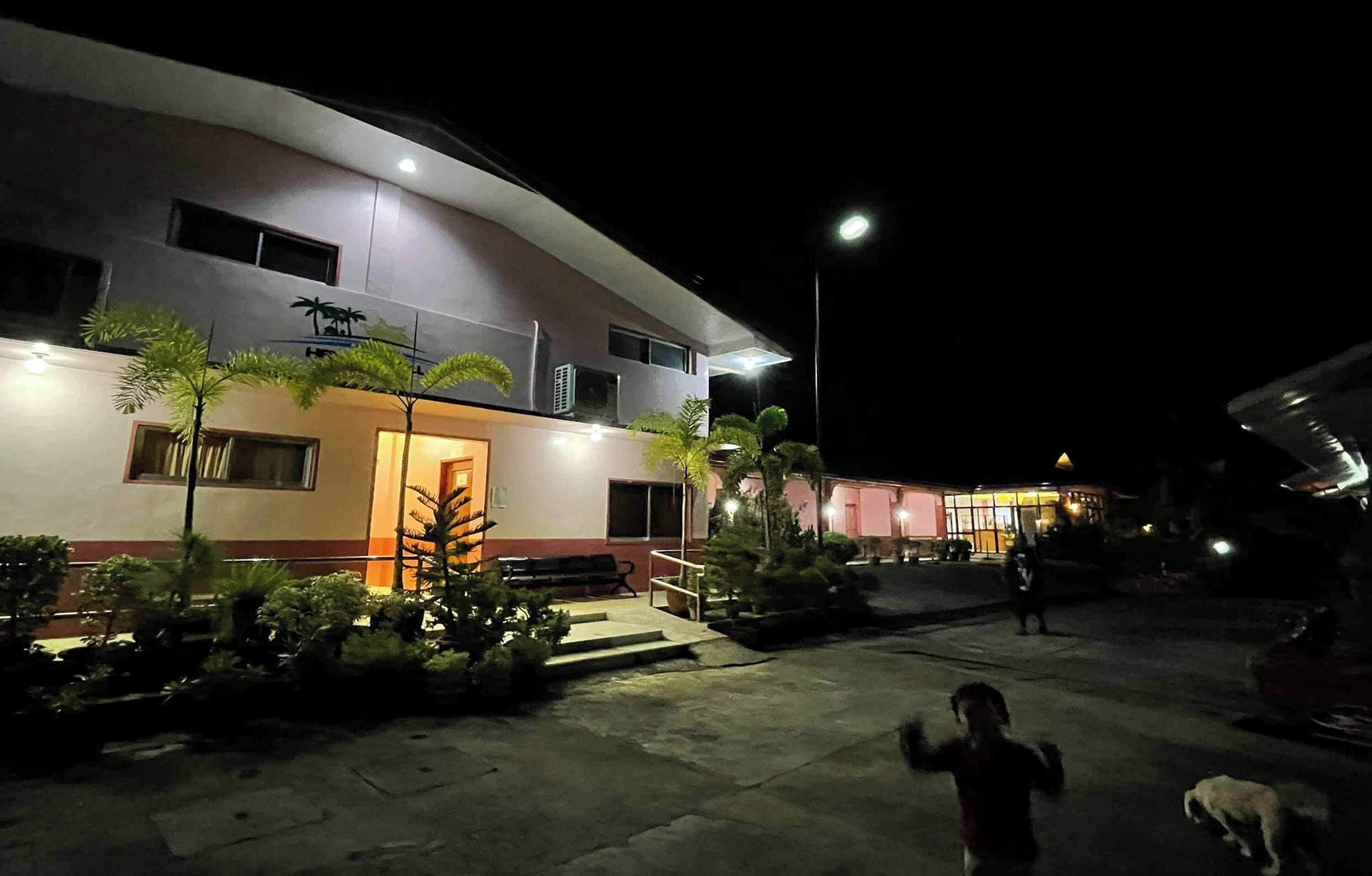 A modern building with a curved facade, multiple windows, and a well-lit entrance.