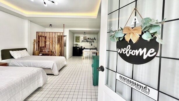 A hotel room with two beds, a kitchen area, and a welcome sign. - Bann Kam B&B (Krabi)