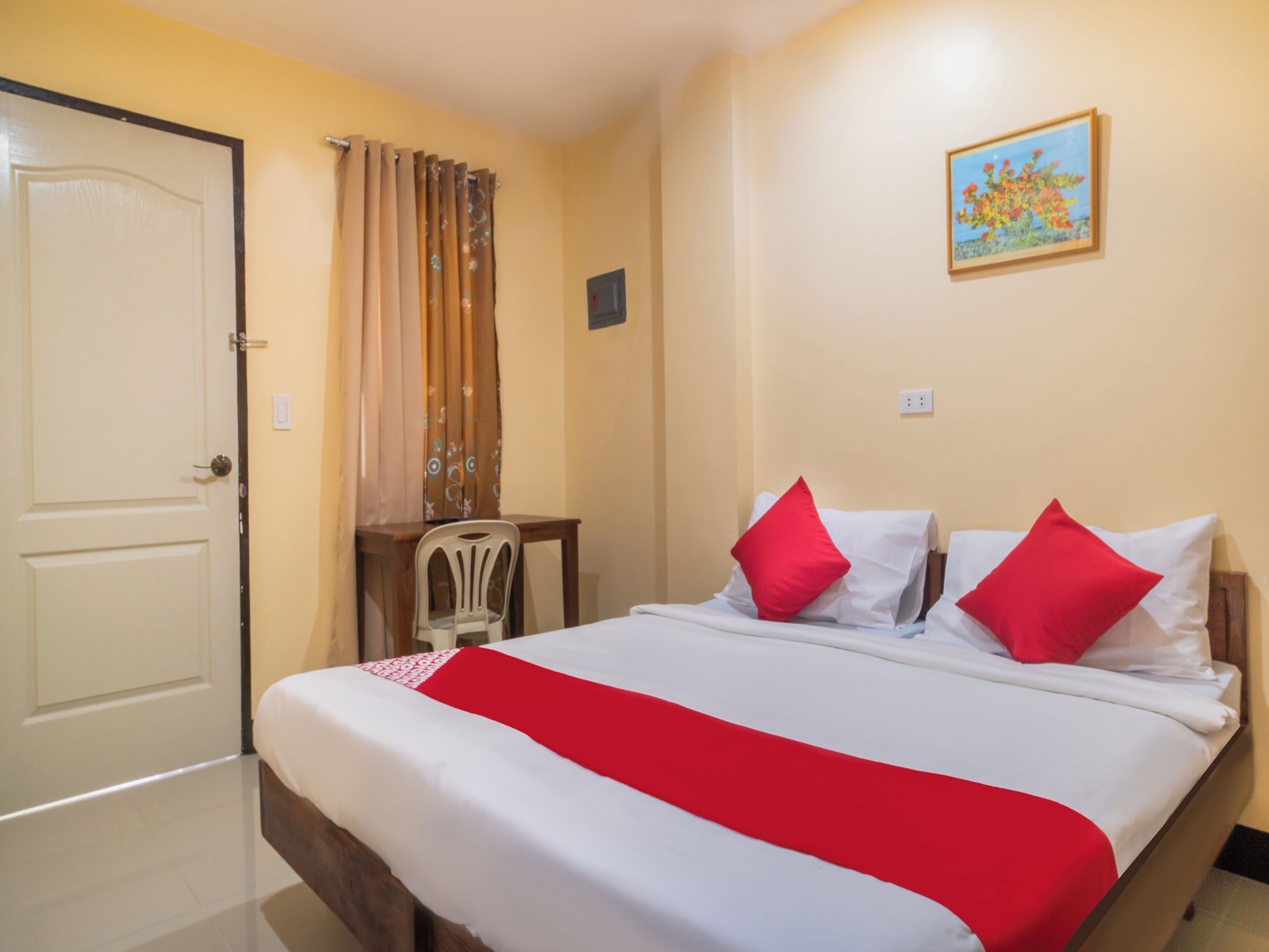 Ein Hotelzimmer mit Bett, Schreibtisch, Stuhl und Tür.