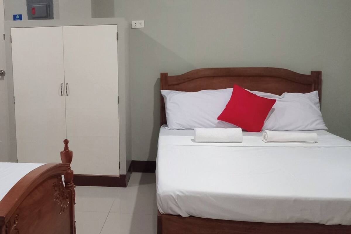 Una habitación de hotel con cama, armario y una mesita.