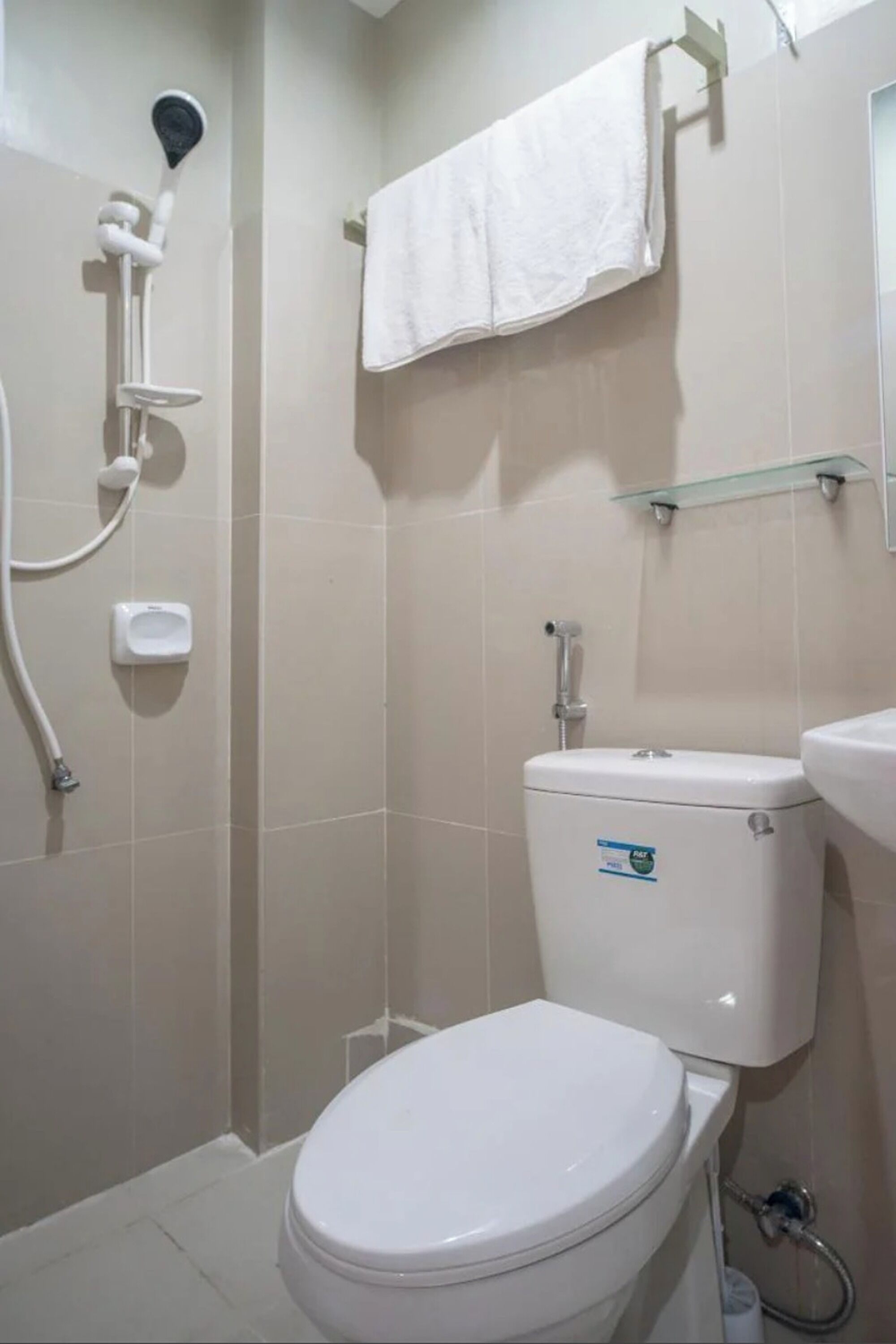 A bathroom with a toilet, a shower, and a sink.
