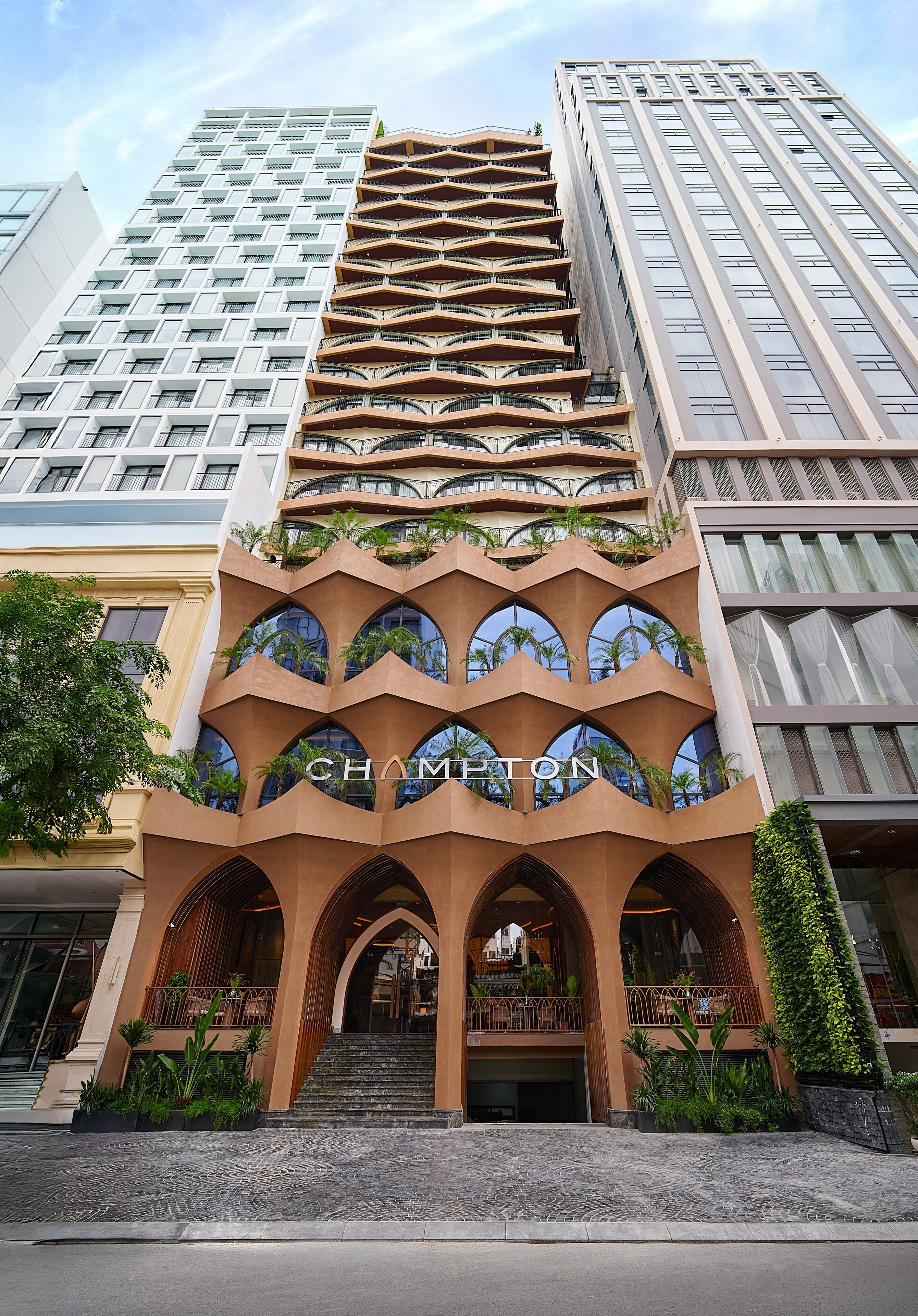 A hotel with a unique architectural design featuring multiple balconies and arched entrances.