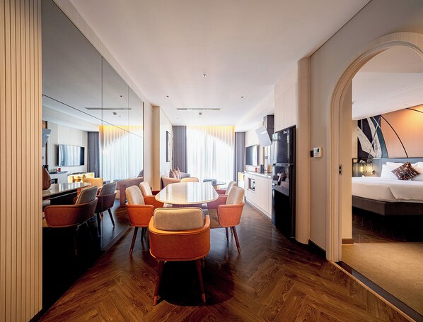 A modern hotel room with a dining area, a kitchen, and a bedroom. - Champton Nha Trang (Nha Trang)