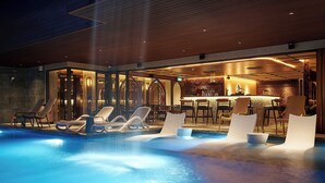 A modern indoor pool area with lounge chairs and a bar. - Champton Nha Trang (Nha Trang)