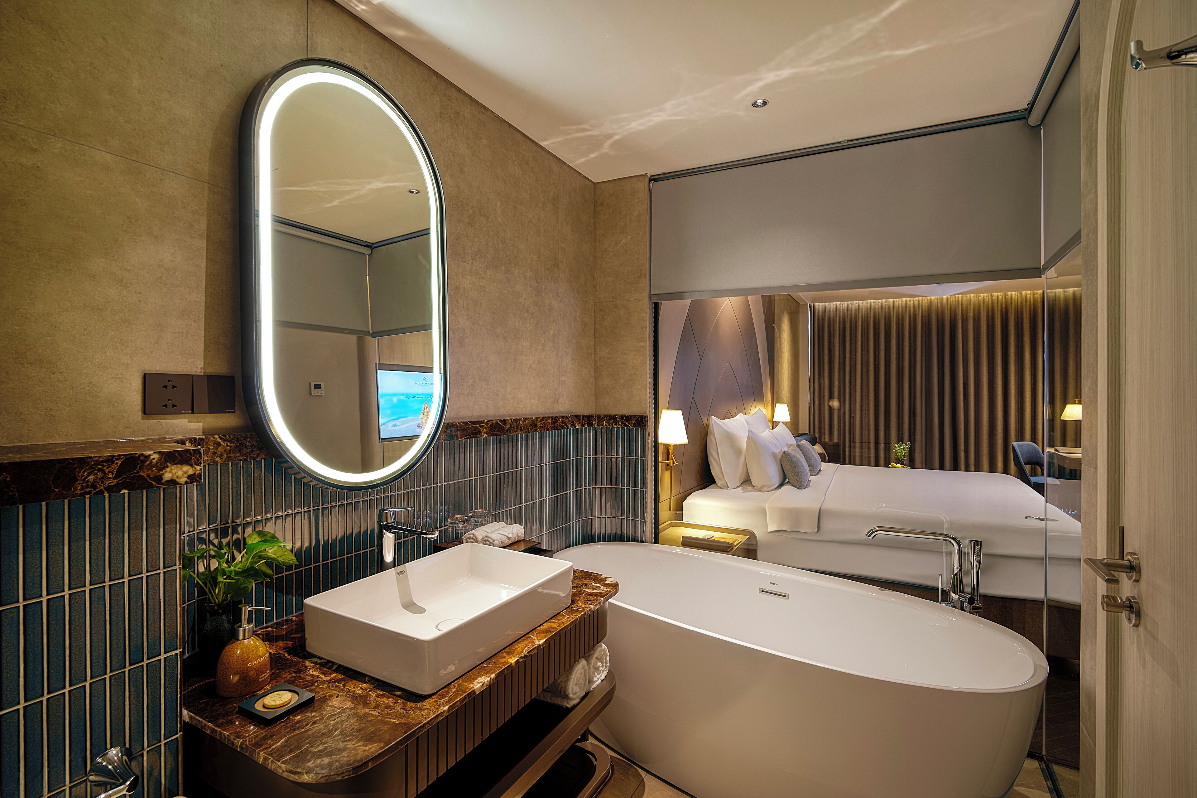 A modern bathroom with a freestanding bathtub, a large mirror, and a vanity with a sink and decorative items.