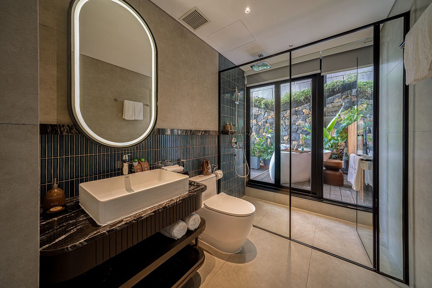 A modern bathroom with a large mirror, a bathtub, and a toilet.