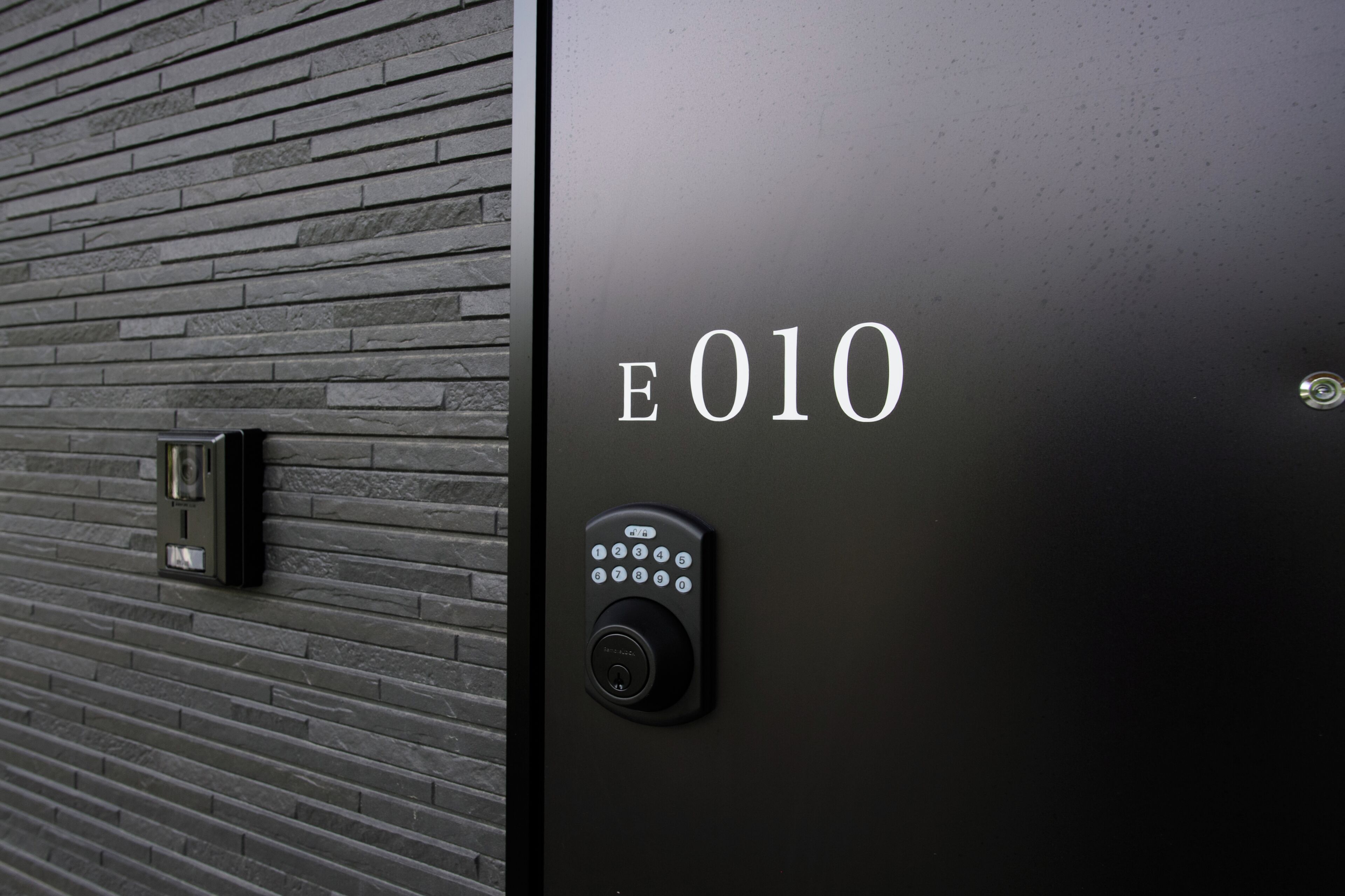 A modern elevator with a keypad and a digital display indicating the floor number 'E010'.