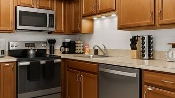 A fully stocked kitchen with stainless appliances, knife block, and spice rack—ready for any recipe.